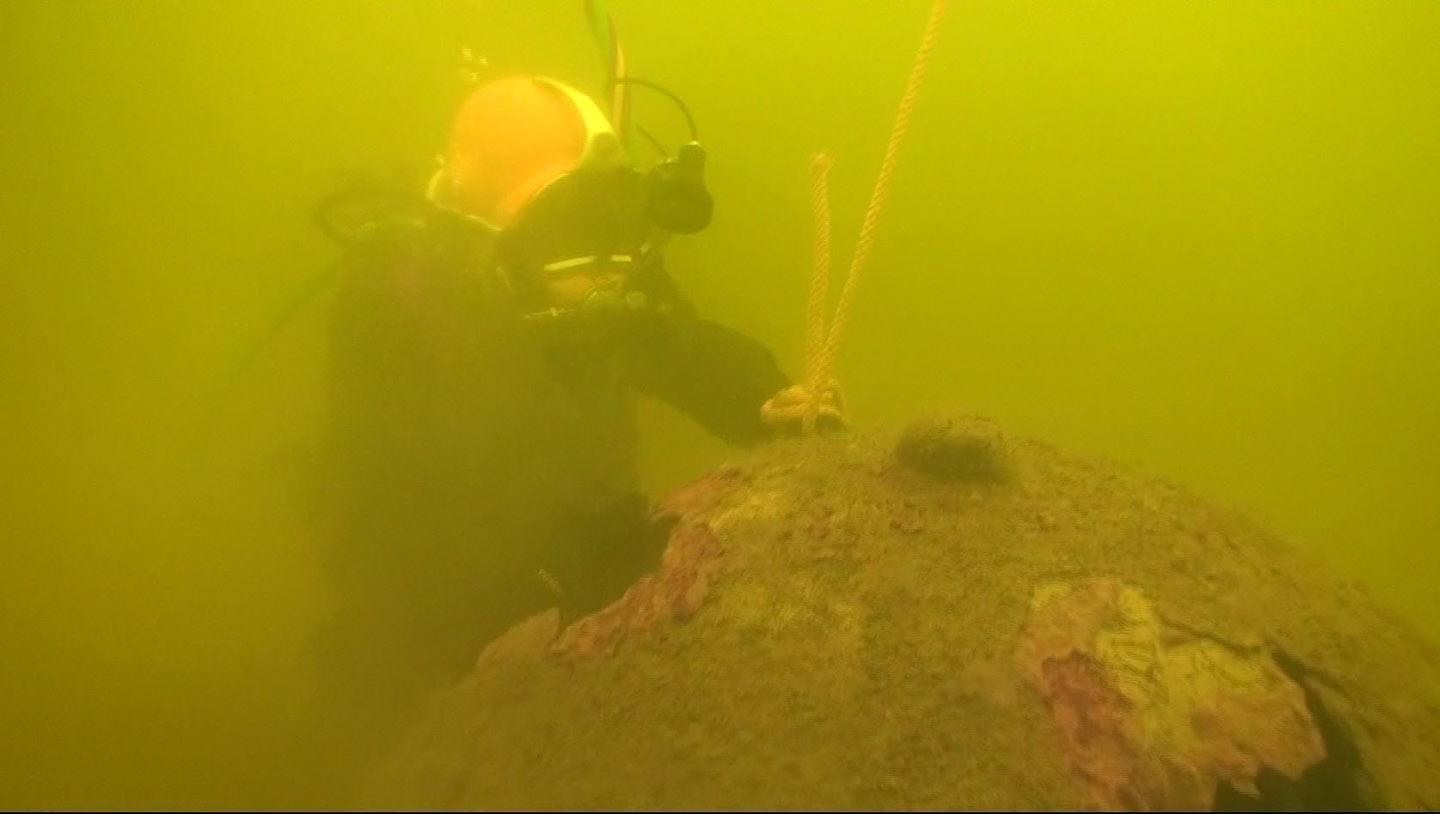 Diver recovering a discarded German WW II moored mine Diver recovering a discarded German WW II moored mine